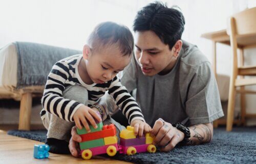 Father and infant son playing with a plastic toy