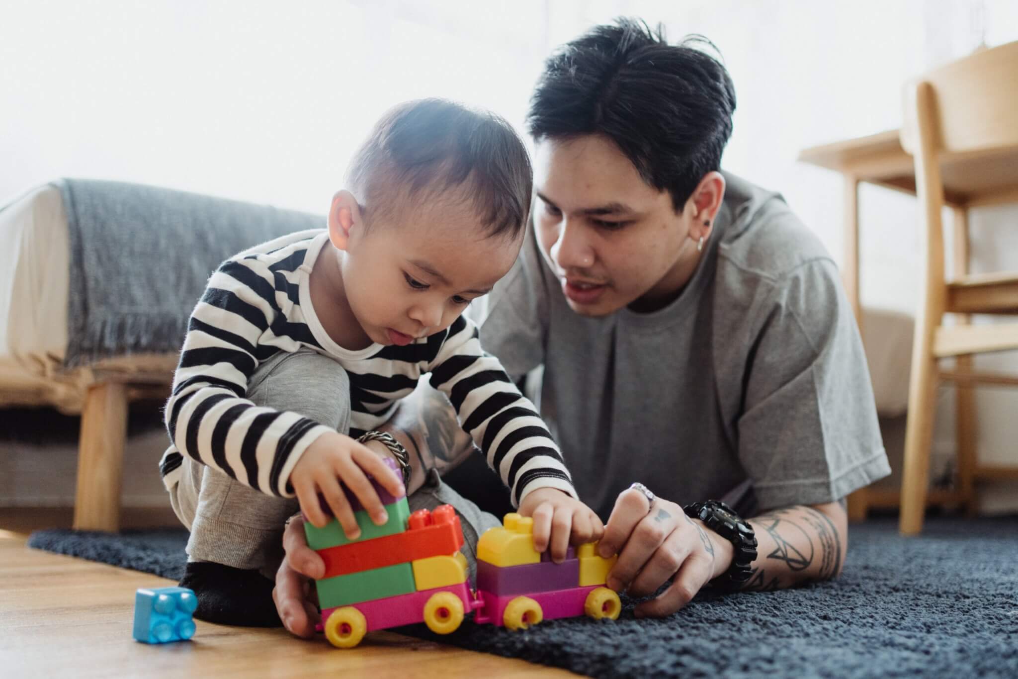 Father and infant son playing with a plastic toy