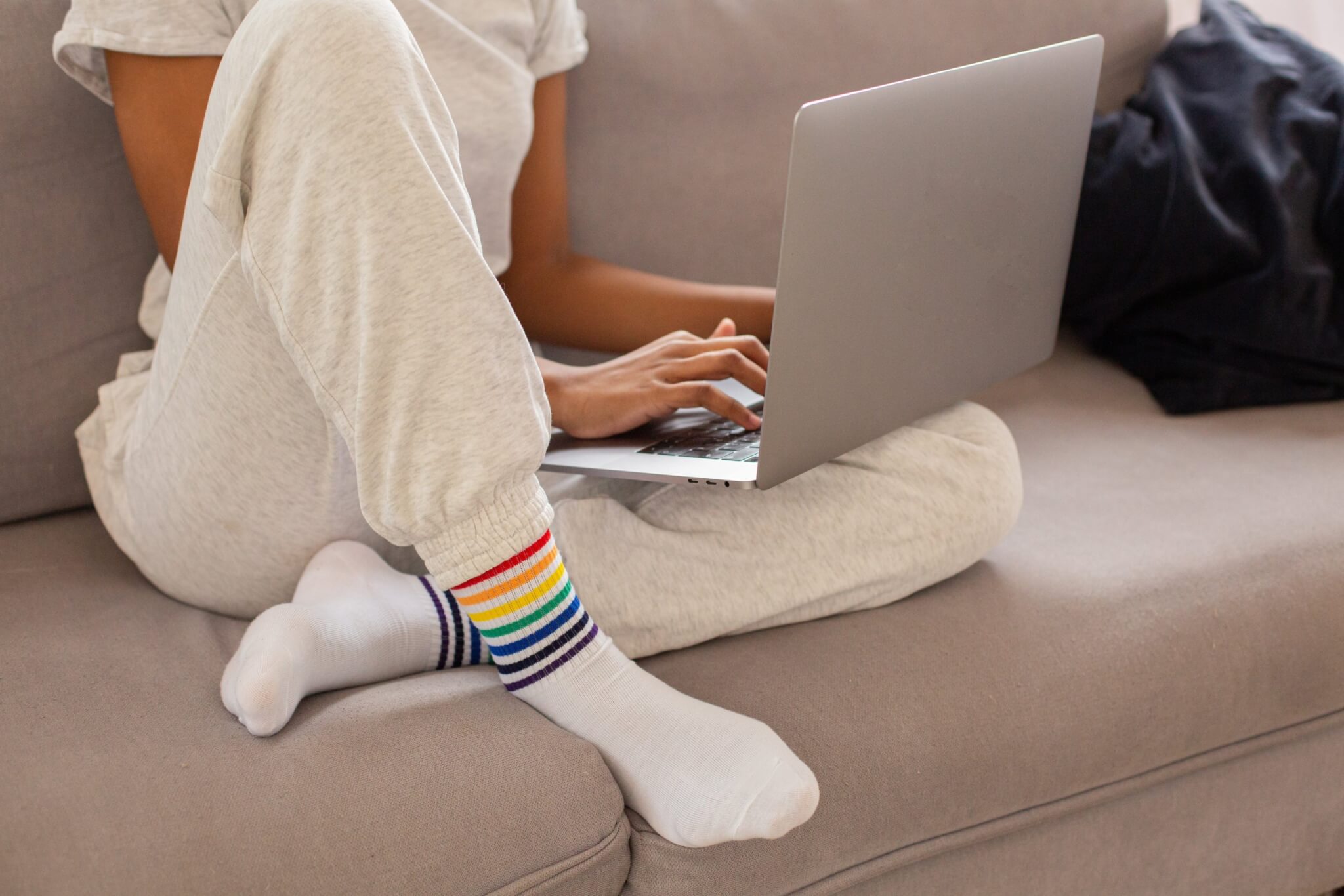 woman working on computer in sweatpants on the couch