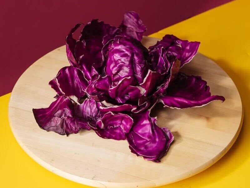 Fresh Red Cabbage Leaves on Wooden Plate