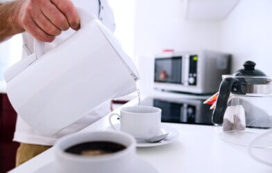 Person using electric kettle to pour tea