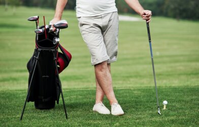 Golfer leaning on golf bag