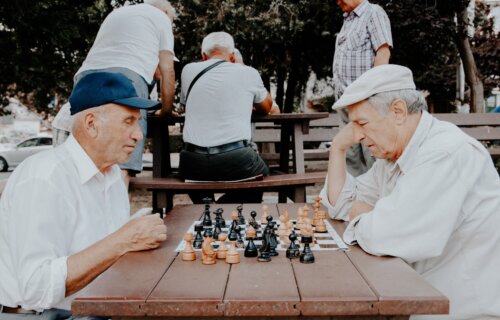 Older men playing chess outside in the city