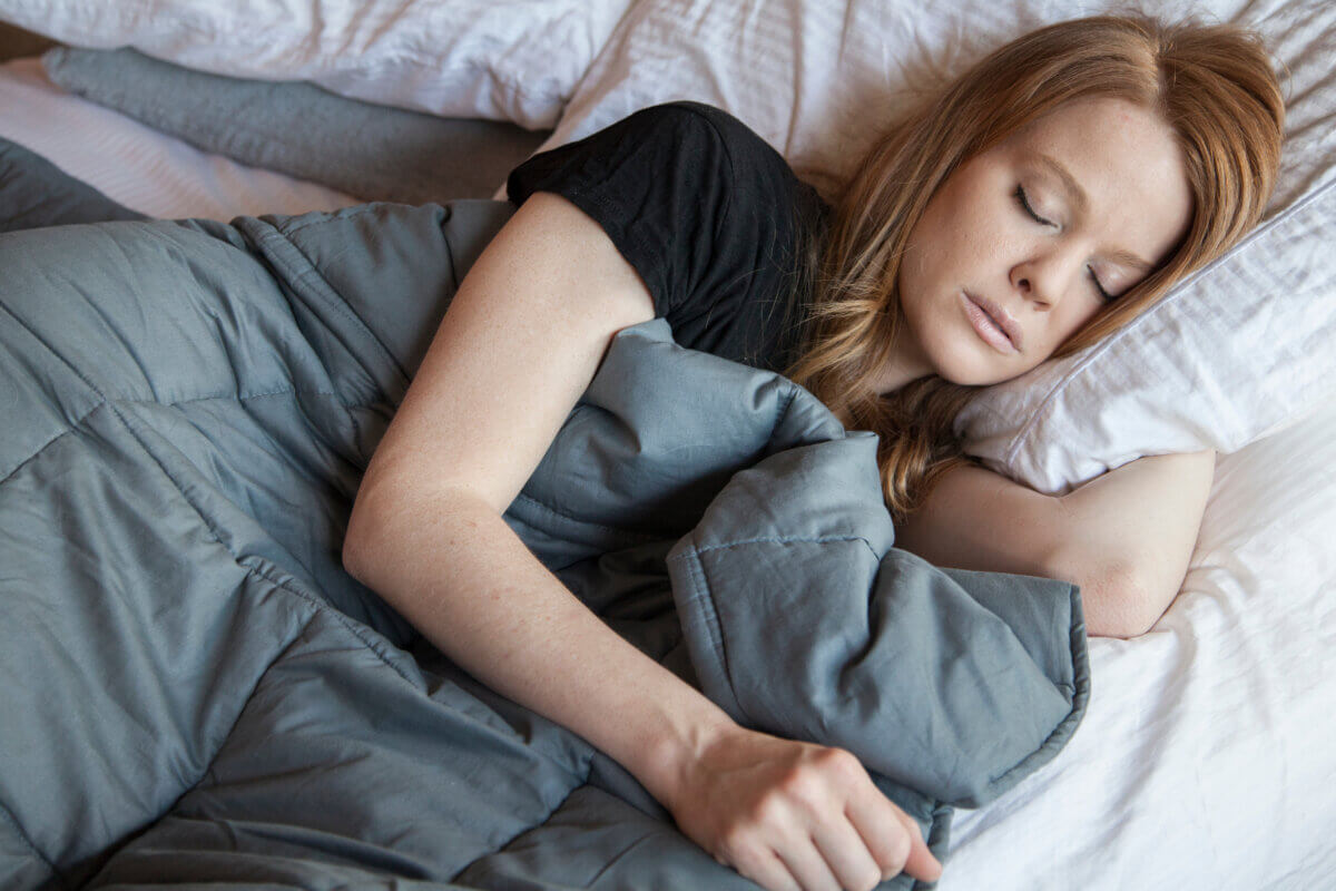 woman sleeping under weighted blanket