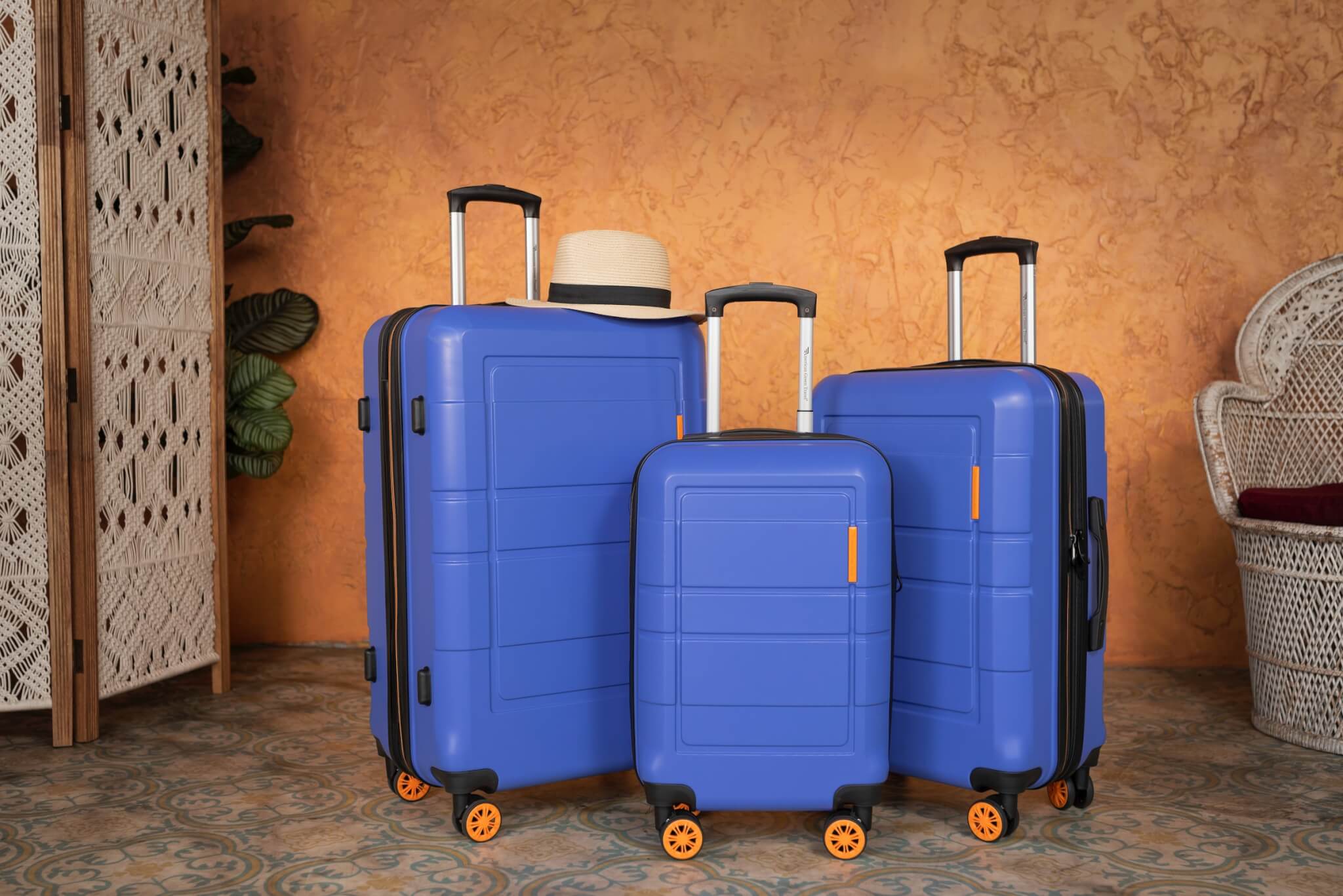 three blue hard suitacases with orange wheels