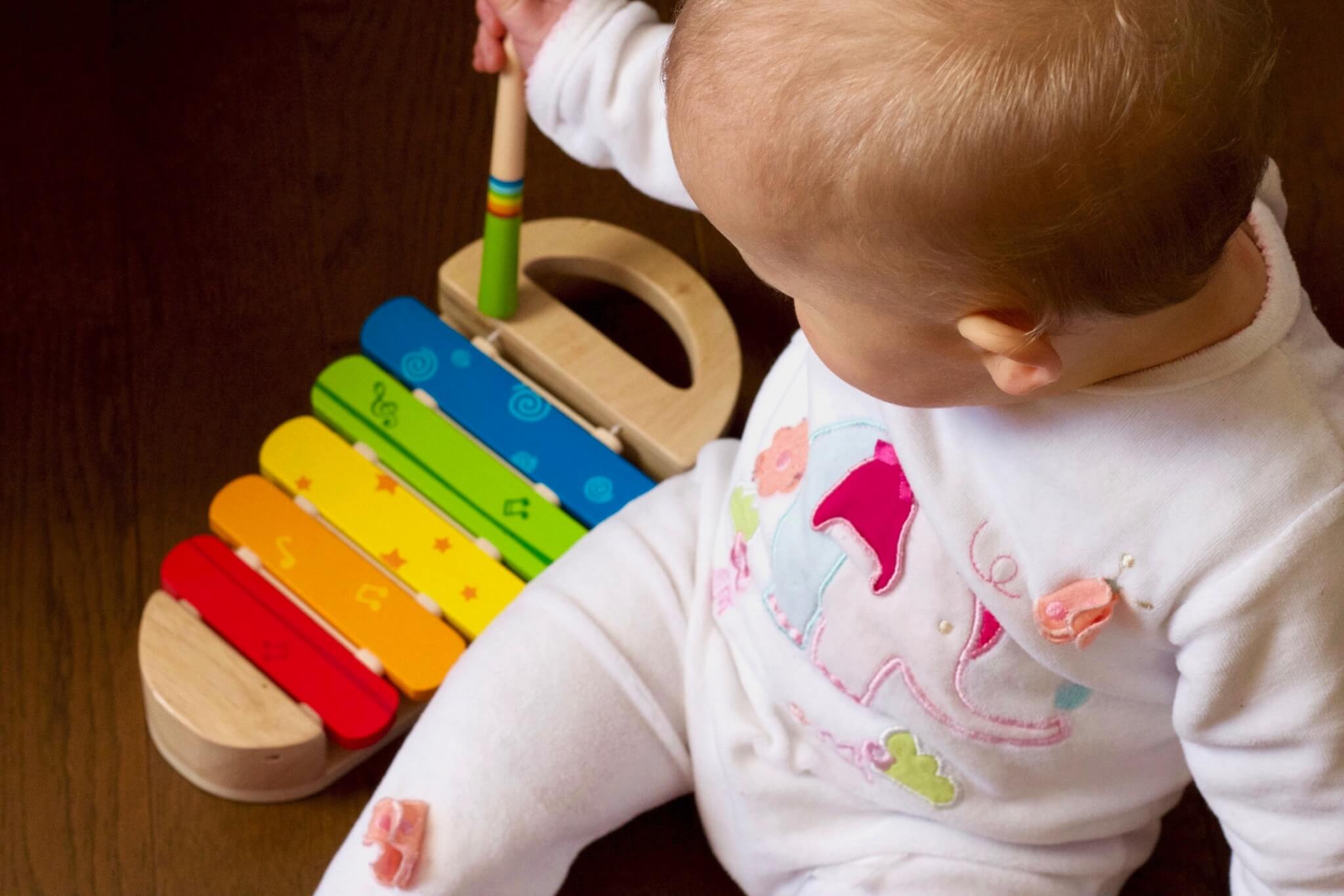 baby playing with a wooden toy