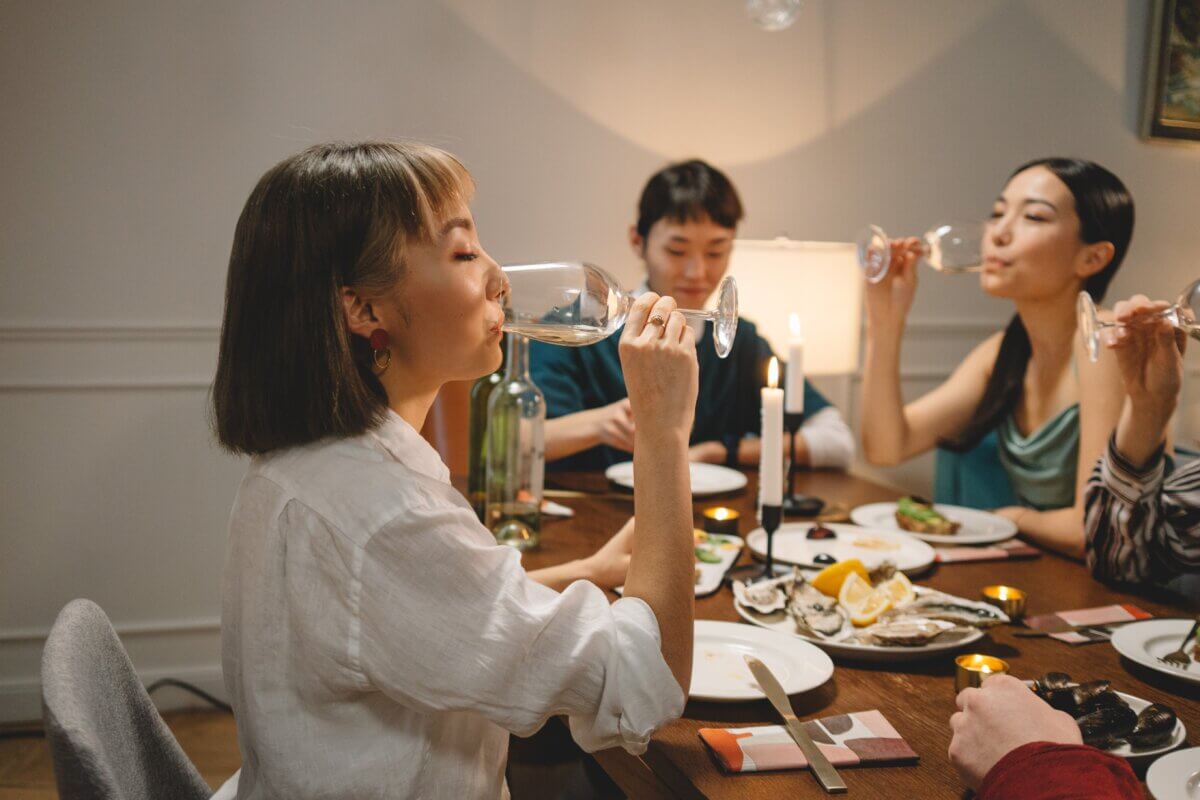 Asian woman drinking alcohol at a dining table