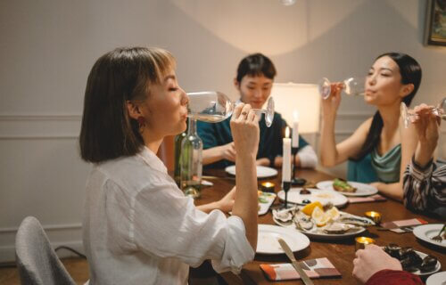 Asian woman drinking alcohol at a dining table