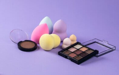 Makeup sponges of various sizes and shapes with makeup palettes