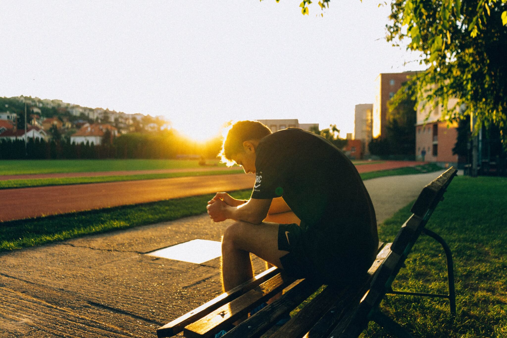 Male athlete sitting on a bench sad