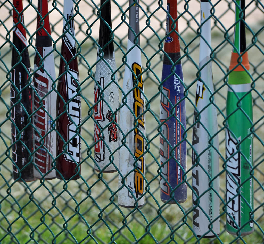 image of metal baseball bats hanging from the fence