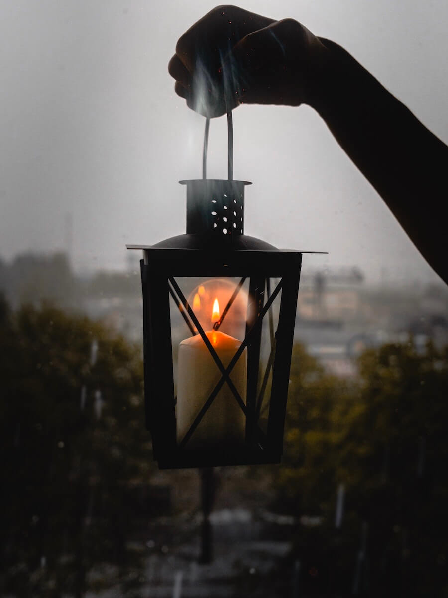 Someone holding a Citronella candle lantern outside