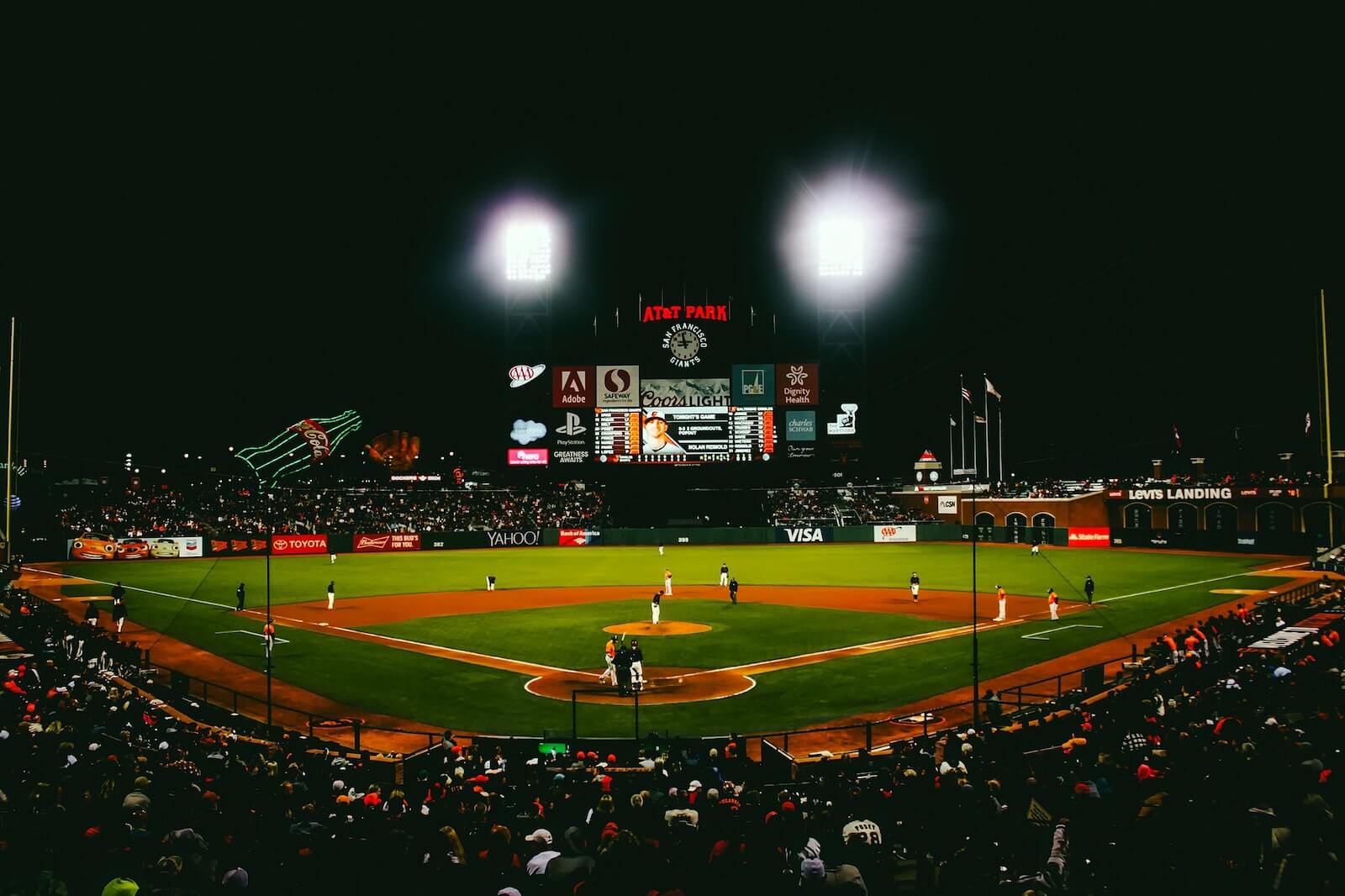 view from stands of behind home plate of baseball stadium with lights on