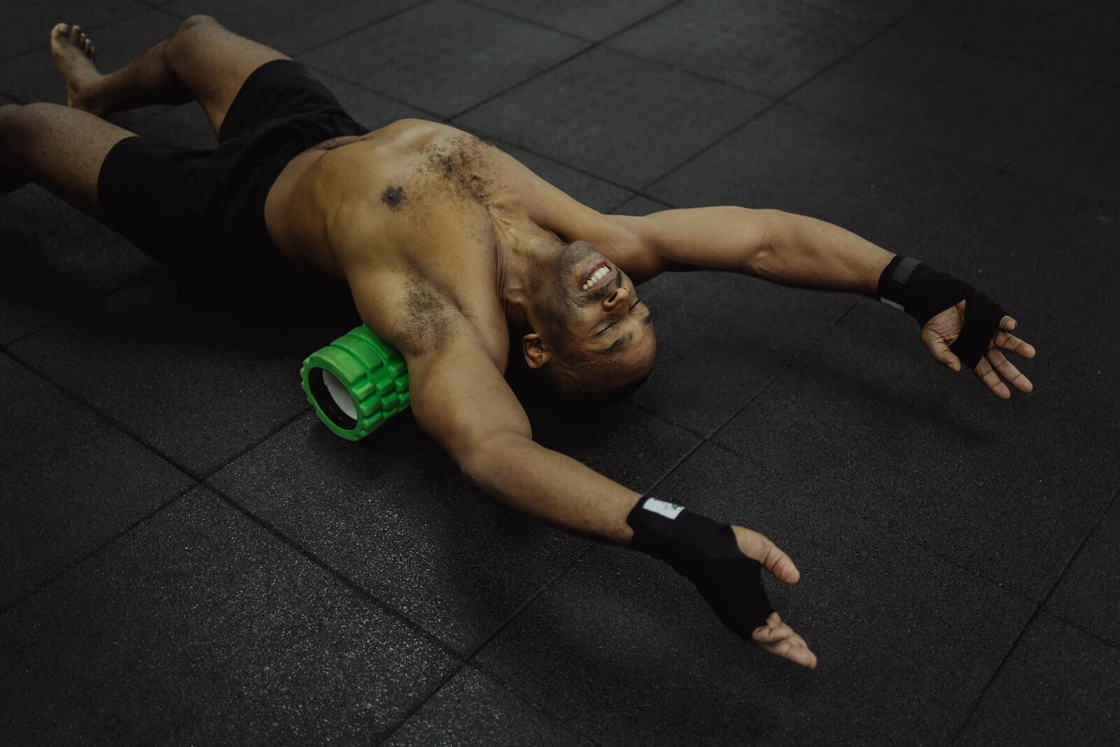 Man Lying With a Foam Roller on His Back