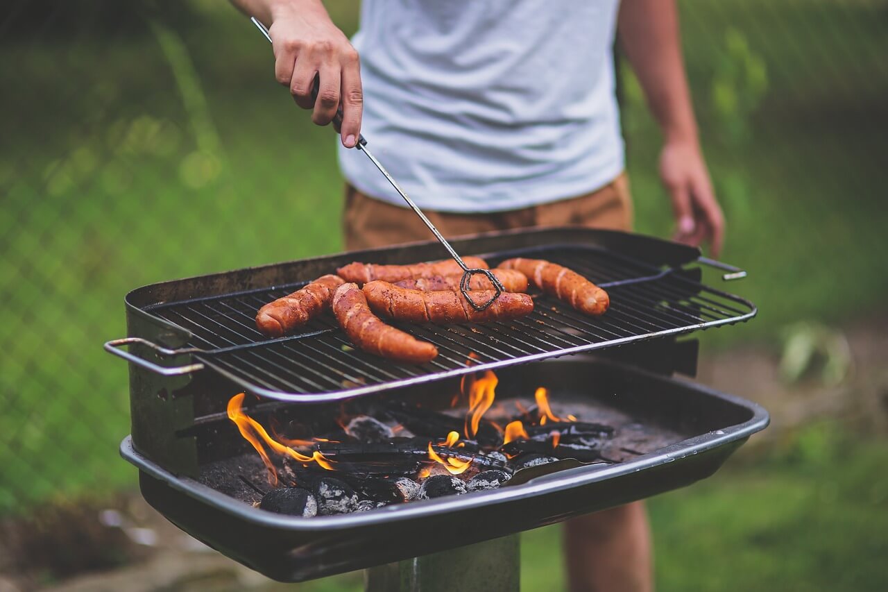 image of person cooking meat on the grill