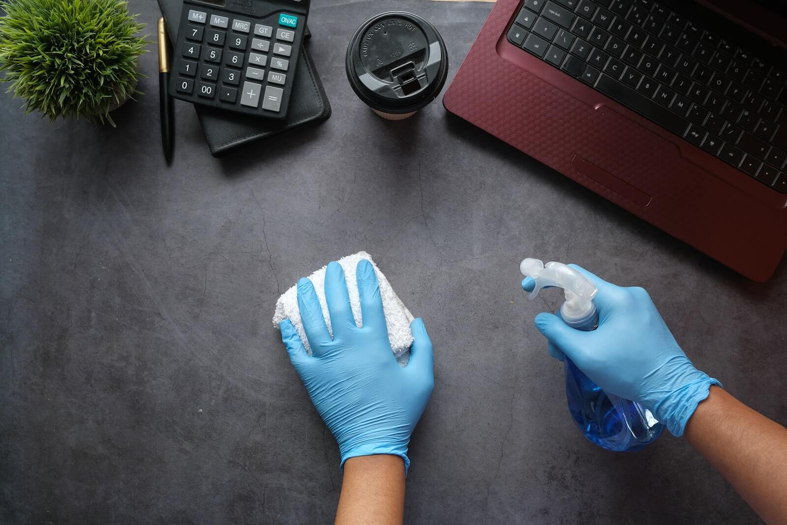 person in gloves cleaning a table