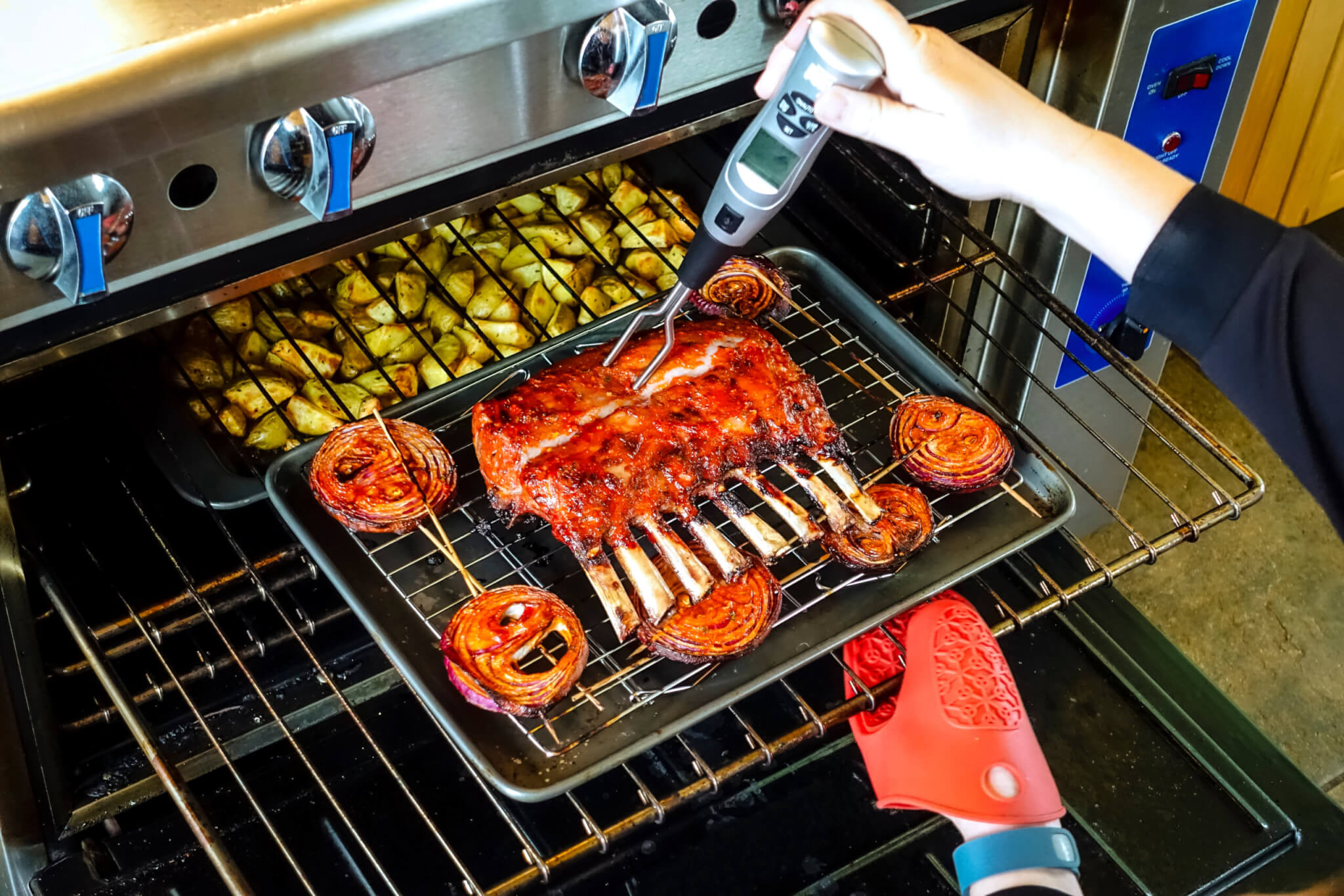 Cooking rack of lamb in oven and checking temperature with meat thermometer