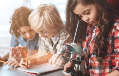 Children doing a science or STEM project with microscope