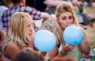 Concertgoers doing nitrous oxide balloons