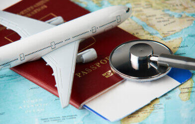 Medical tourism: Plane and passport with stethoscope on map