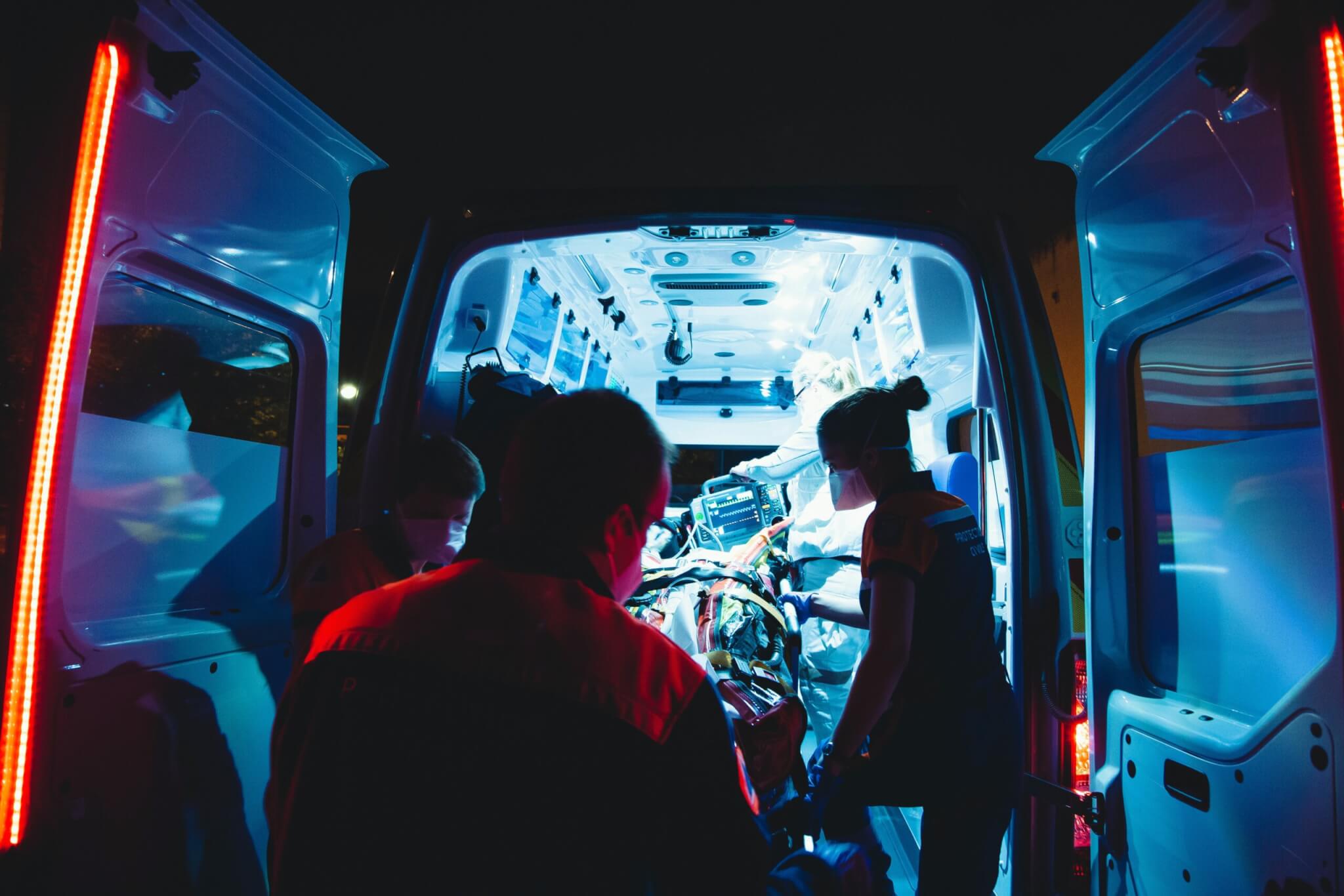 Paramedics loading person into ambulance