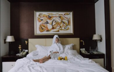 Woman laying in hotel room bed