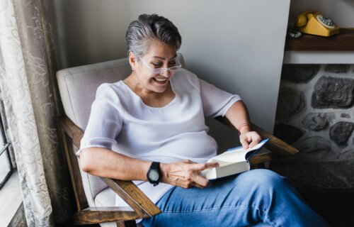 Woman wearing reading glasses while reading a book