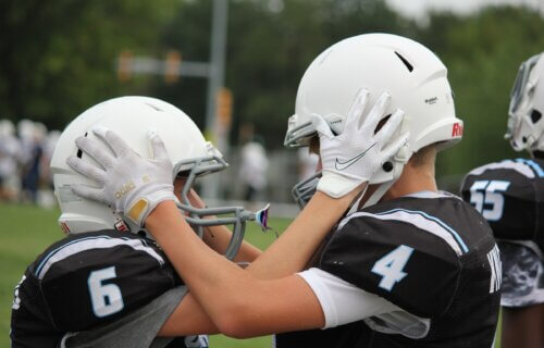 Youth football players grabbing each other's helmets