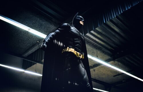 Batman standing under steel roof and lights