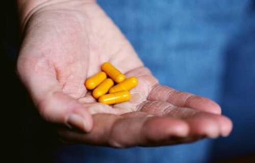 Yellow supplements in a person's hand