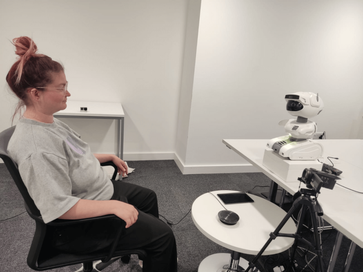 woman sitting with robot mental health coach
