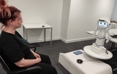 woman sitting with robot mental health coach