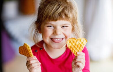 A little girl eating waffles