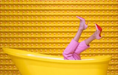 A woman wearing Louboutin's in a yellow bath tub