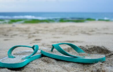 Flip flops on the beach in front of the ocean