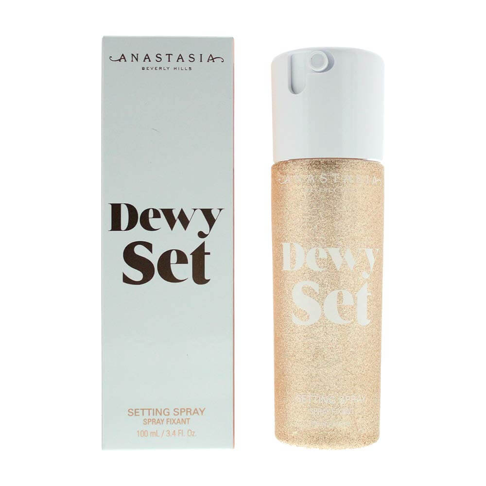 clear spray bottle with gold shimmery liquid next to grey box