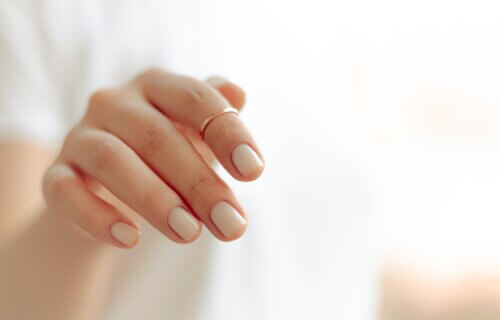 woman's hand with pale pink nail polish