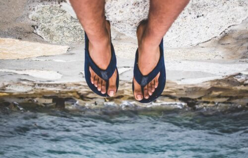 Someone wearing flip flops sitting on a cliff