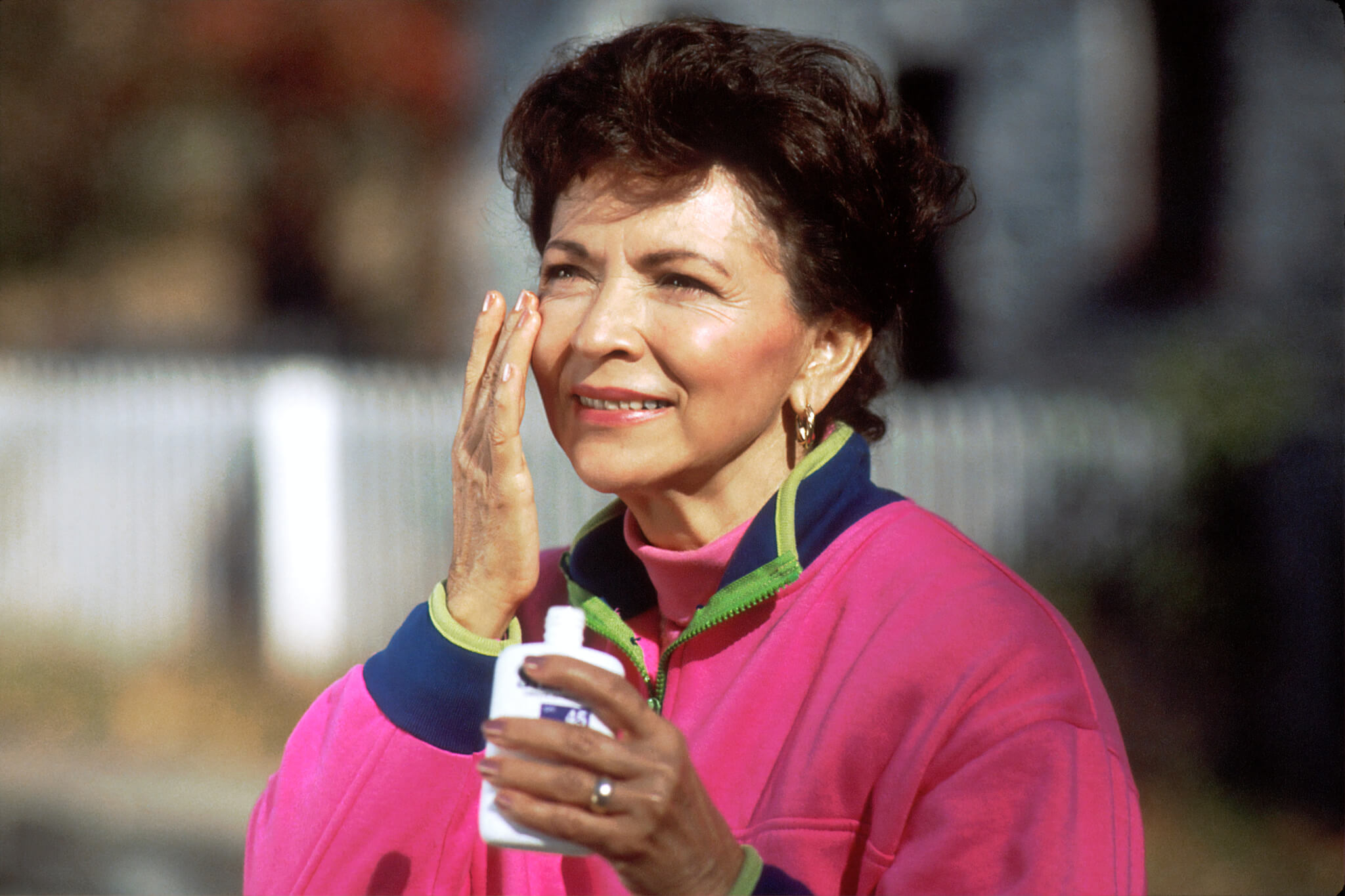 A woman applying tinted sunscreen