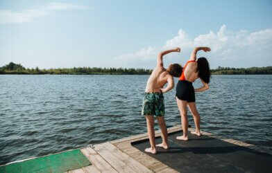 teens exercising and stretching on a dock