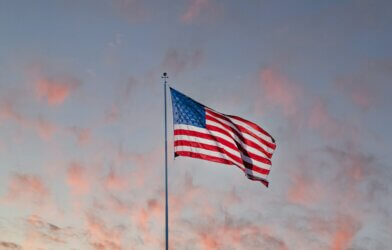 usa flag on pole under sunset sky with clouds