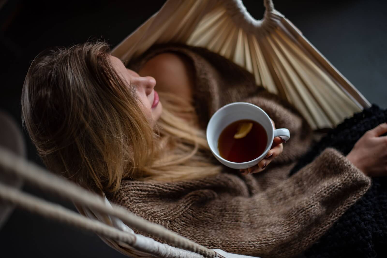 Woman on hammock holding cup of tea