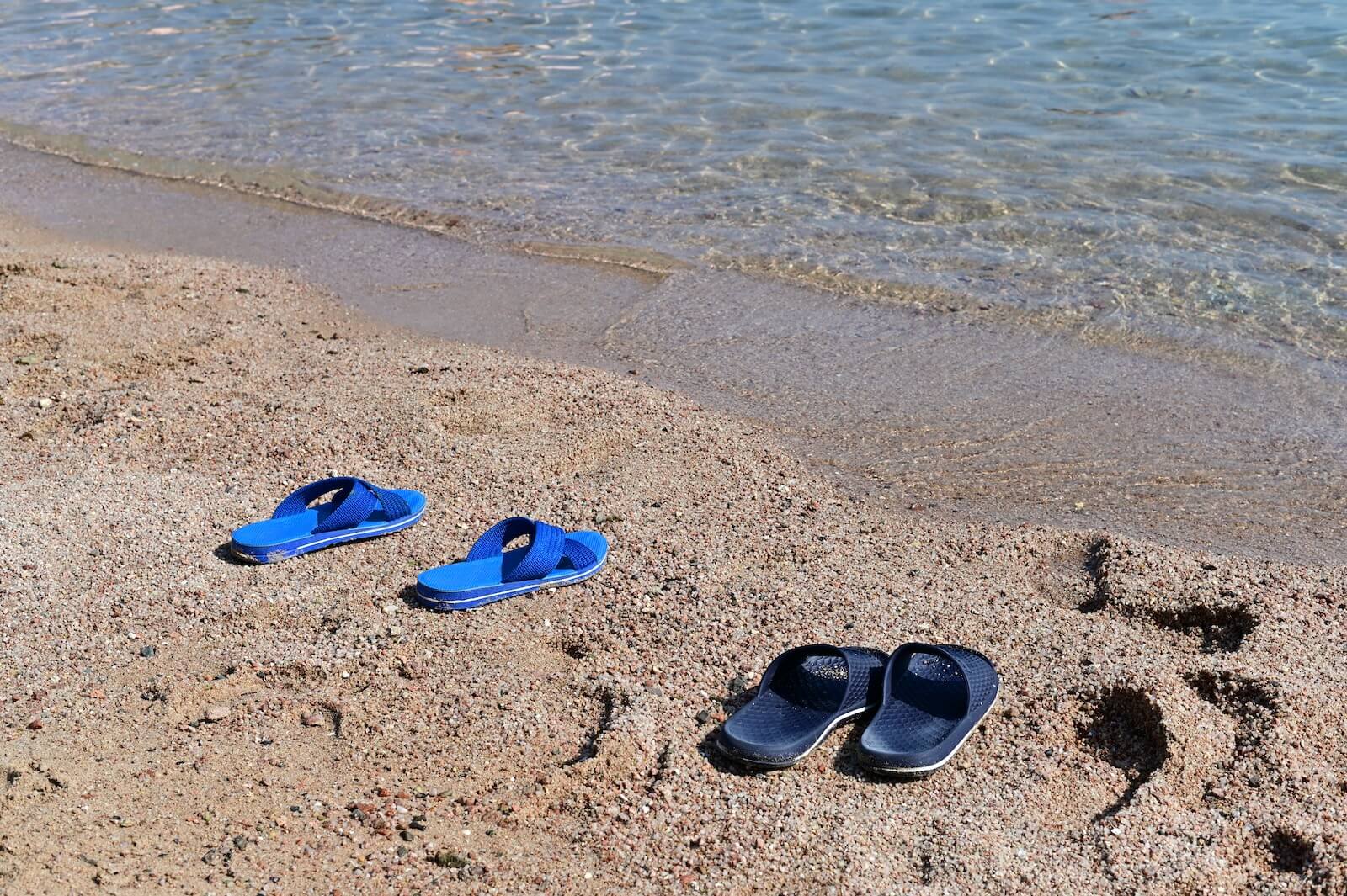 Two pairs of flip flops on the beach