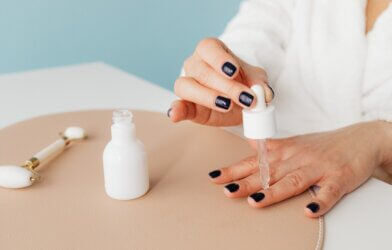 Woman applying oil to cuticles