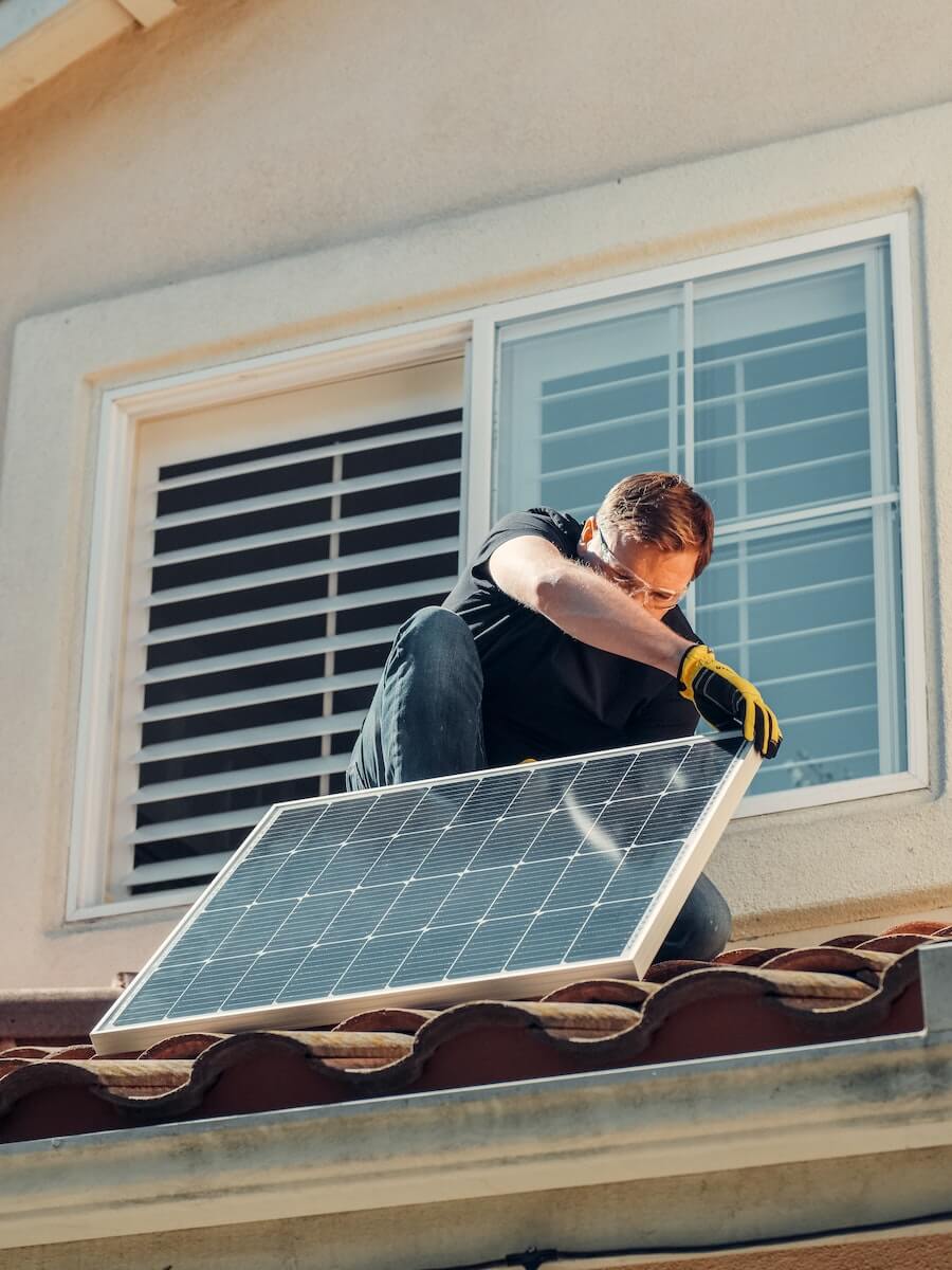 Man Installing Solar Panel on Roof