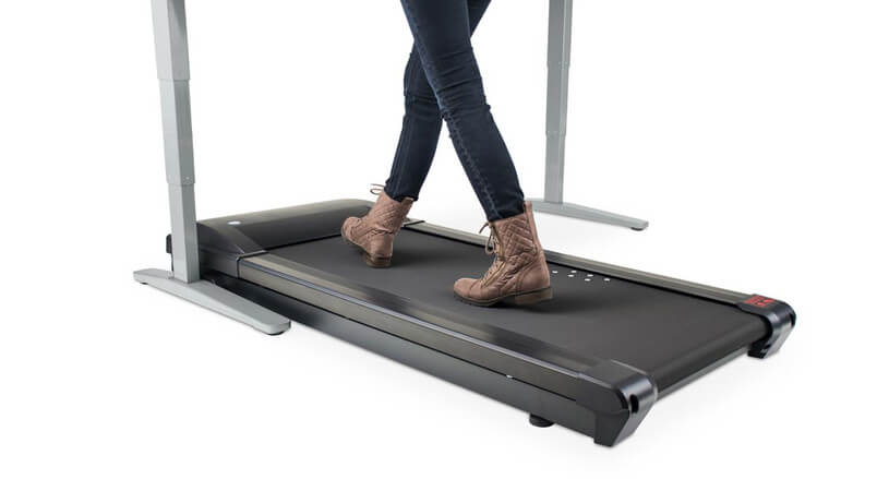 woman in jeans and boots walks on treadmill