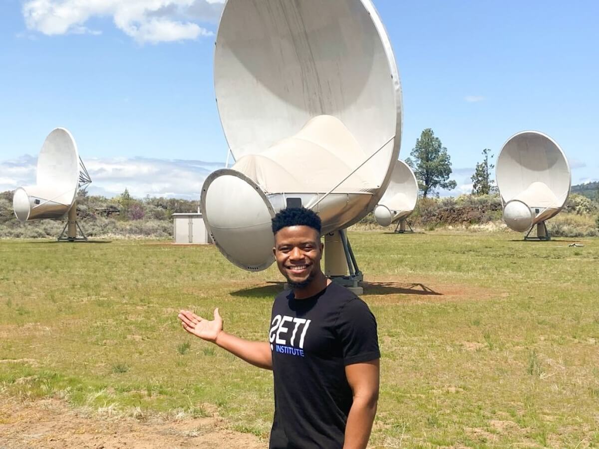 SETI's Ramiro Saide standing by a radio telescope