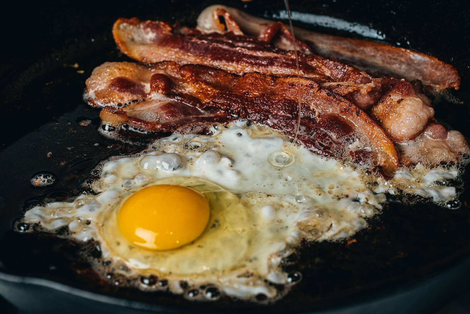 Bacon and a fried egg on the stovetop