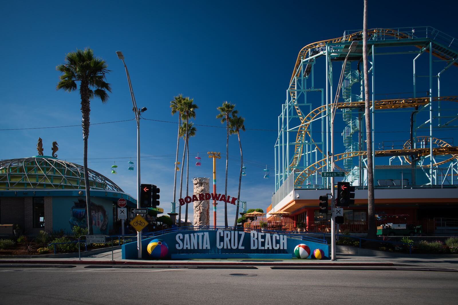 a santa cruz beach sign in front of a roller coaster