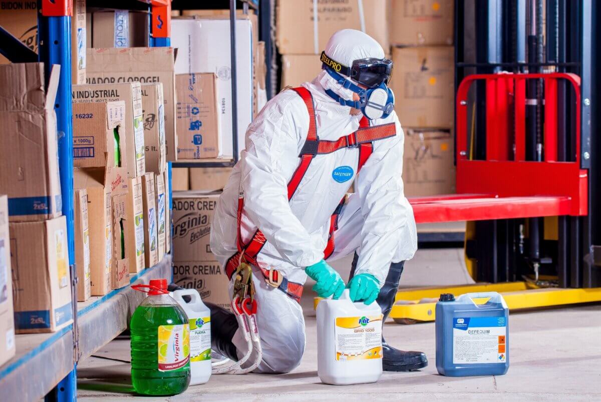 Worker in protective clothing handling chemicals